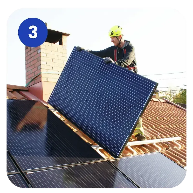 Ein Solarteur installiert ein Solarmodul auf einem Dach.