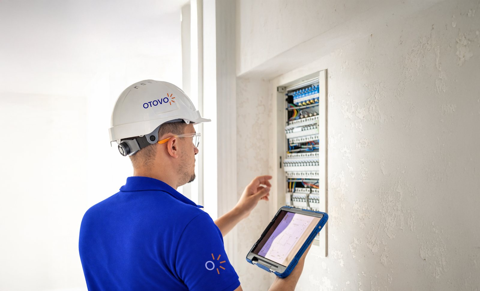 Otovo-Techniker prüft einen Zählerschrank mit einem Tablet